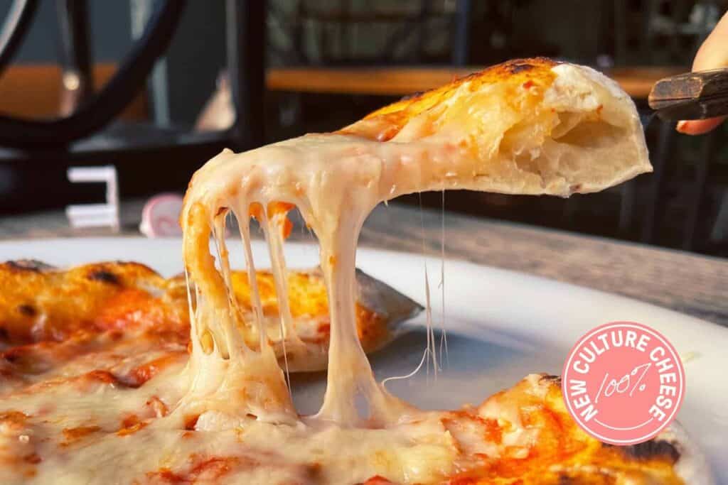 Slice of pizza with melting New Culture cheese