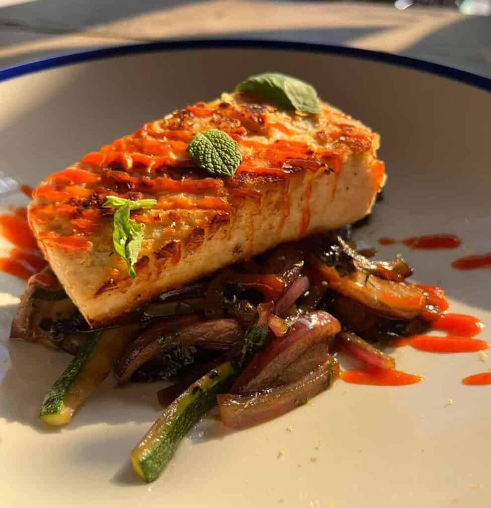 A vegan mycelium white fish filet with sauce.