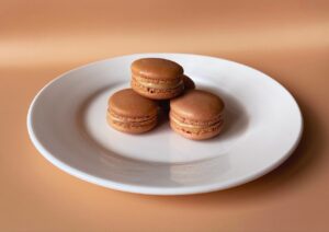 Drei vegane macarons auf weißem teller
