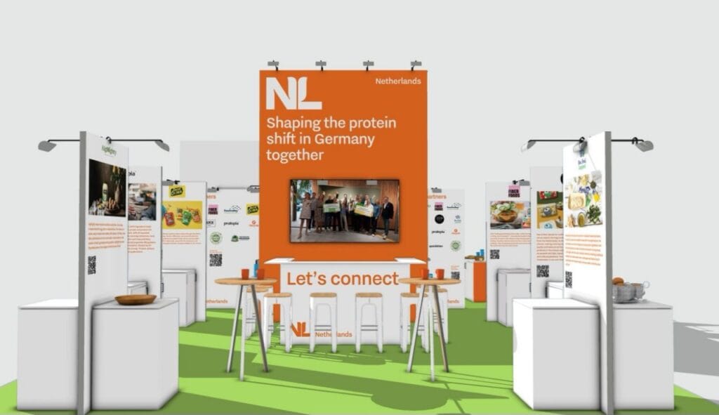 Vegan messe stand mit grünen elementen und informationsmaterialien.