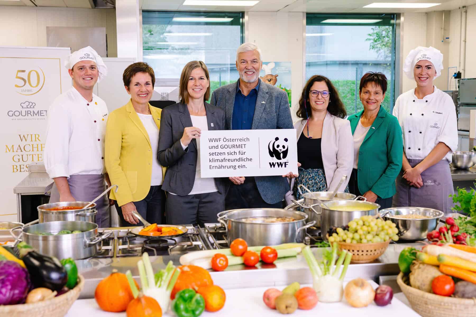 Wwf-österreich-geschäftsführerin andrea johanides mit gourmet geschäftsführer herbert fuchs und den engagierten kooperationsteams in der entwicklungsküche von gourmet © gourmet