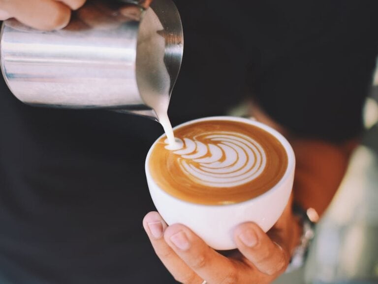 Barista holding white cup making barista art