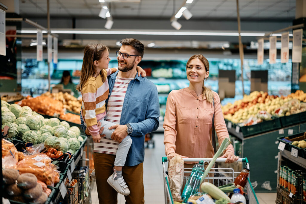 Happy family buying groceries in supermarket.